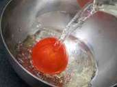 2. Die Tomate in eine Schüssel legen und mit kochendem Wasser übergießen. Foto: Andrea Warnecke/dpa-tmn 2. Die Tomate in eine Schüssel legen und mit kochendem Wasser übergießen. Foto: Andrea Warnecke/dpa-tmn