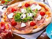 close up of delicious italian pizza with ham, mozzarella, tomatoes and arugula (sebasnoo) close up of delicious italian pizza with ham, mozzarella, tomatoes and arugula (sebasnoo)